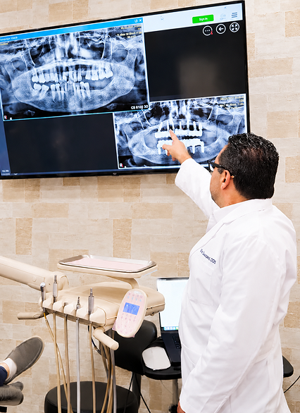 A dentist explaining X-rays on the wall screen